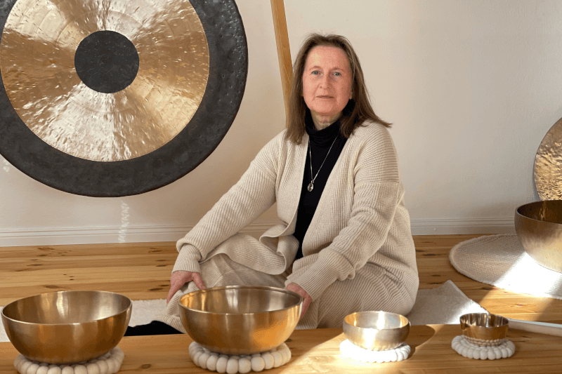 Elisabeth Dierlich im Klangraum mit Klangschalen und Gong